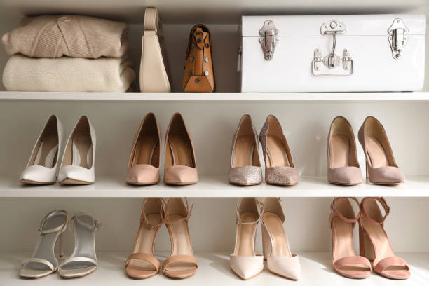 Stylish women's shoes, clothes and bags on shelving unit